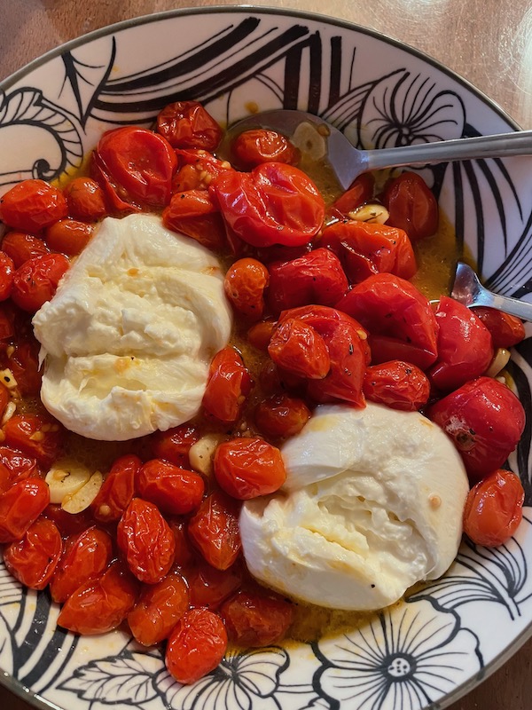 Plate of roasted grape tomatoes and burrata cheese