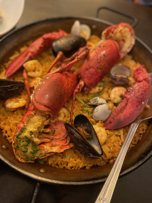Seafood paella with big lobster in the middle