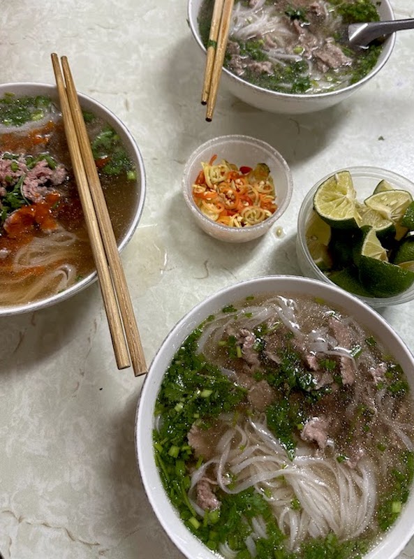 Bowls of pho noodles and lime